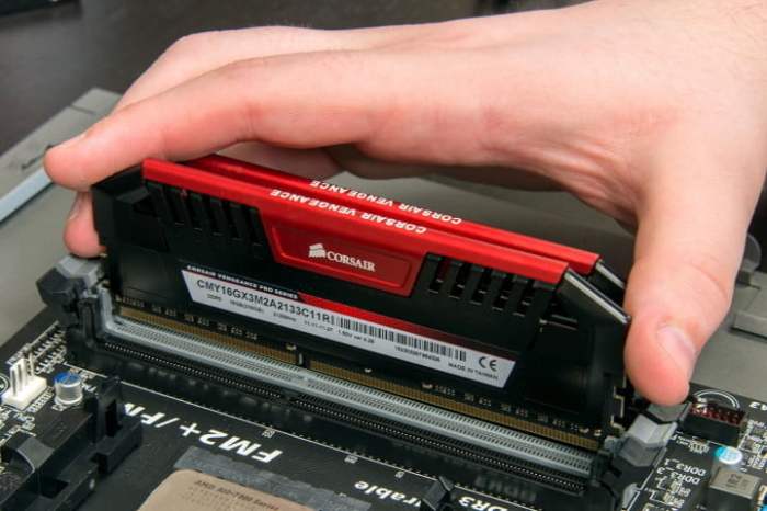 La mano de una persona instalando memoria RAM en una placa base