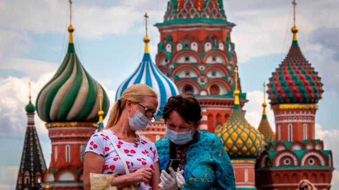 La imagen muestra a dos personas con mascarilla en Moscú.