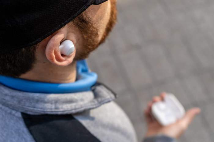 la oreja de una persona con un audífono blanco dentro