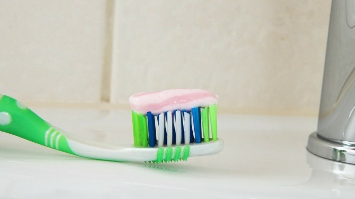 La imagen muestra un cepillo de dientes sobre un lavamanos.