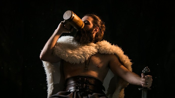 La imagen muestra a un vikingo sentado, tomando cerveza.