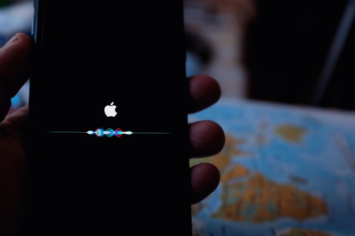 Una persona sostiene un teléfono Apple con la asistente Siri