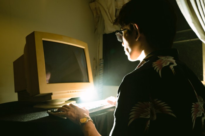 La imagen muestra a un joven utilizando un computador antiguo.