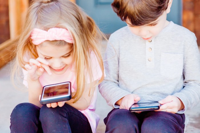 Dos niños con teléfonos inteligentes