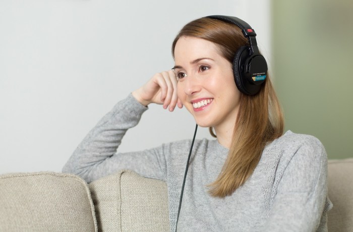 Una mujer utilizando auriculares para escuchar la música después de convertir FLAC a MP3