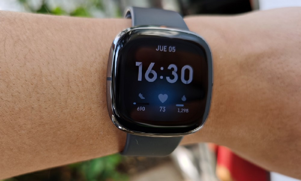 Usuario enseñando el Fitbit Sense