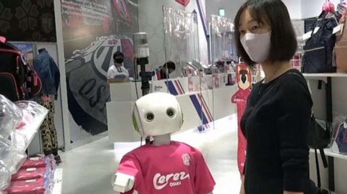 La imagen muestra a un robot que le pide a las personas que usan mascarillas.