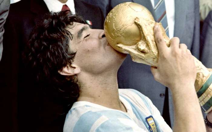 La imagen muestra a Diego Maradona besando la Copa del Mundo de 1986.
