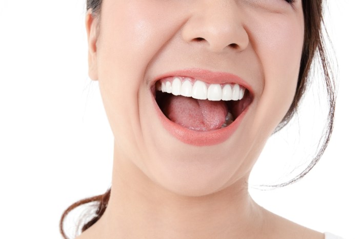 Una mujer muestra sus dientes y su saliva