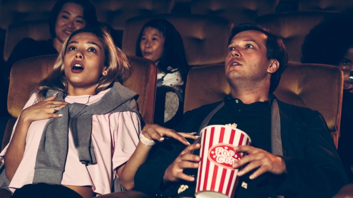 La imagen muestra a una pareja en el cine.