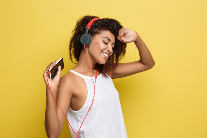La imagen muestra a una joven escuchando música con audífonos.