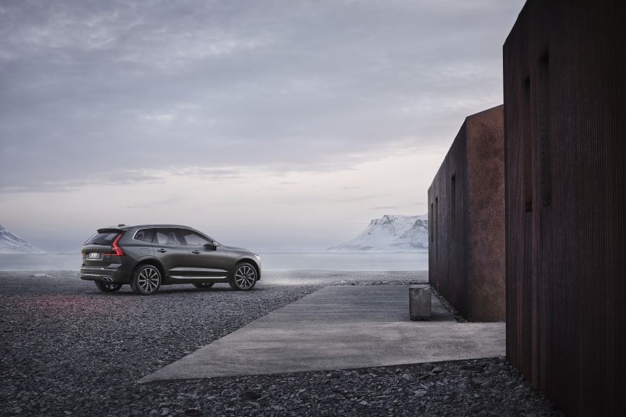 Volvo XC60 Recharge a la orilla de un lago junto a unas construcciones minimalistas