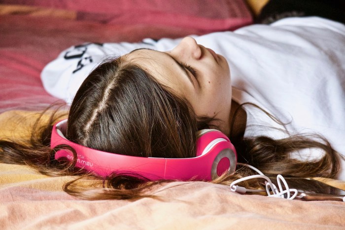 La imagen muestra a una mujer escuchando música.