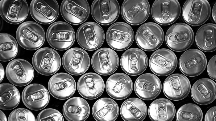 La imagen muestra varias latas de bebida apiladas.