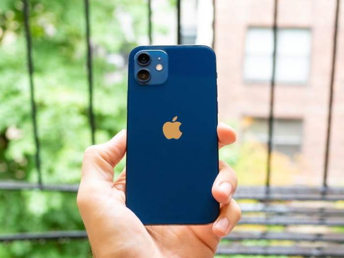 La mano de una persona con un iPhone azul para aprender cómo restaurar el iPhone