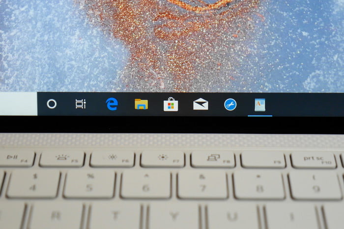 Vista parcial de teclado y pantalla de una laptop Dell abierta y encendida, para comparar la Dell XPS 13 vs. MacBook Pro 13