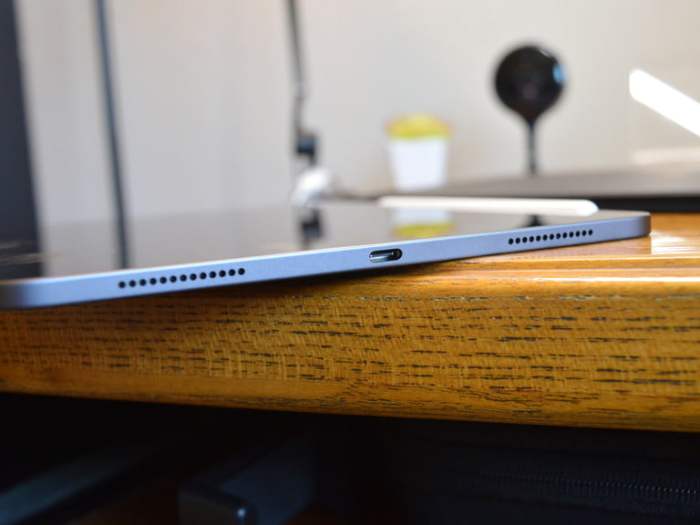 iPad Pro 11 pulgadas sobre una mesa de madera vista de perfil parcialmente, en color azul
