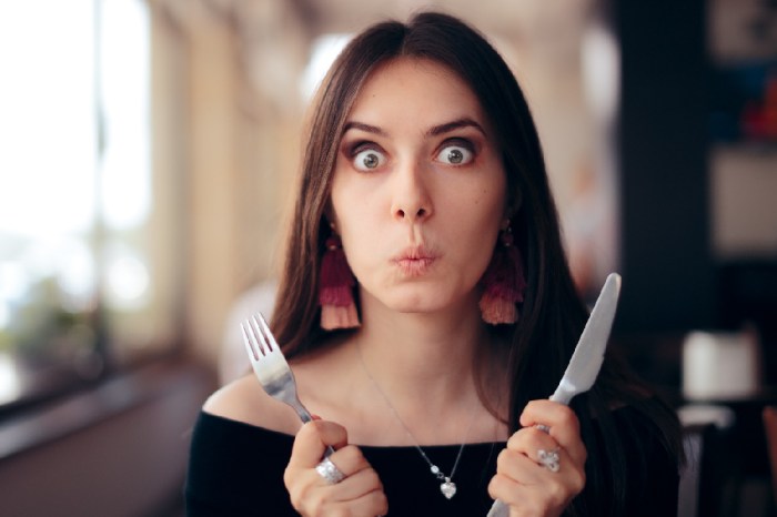 Una mujer con un tenedor y un cuchillo