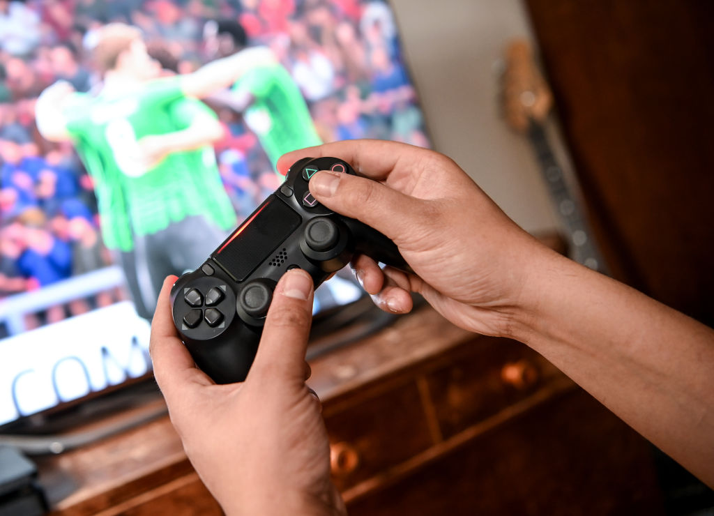 Una persona juega un videojuego de fútbol en PlayStation 4