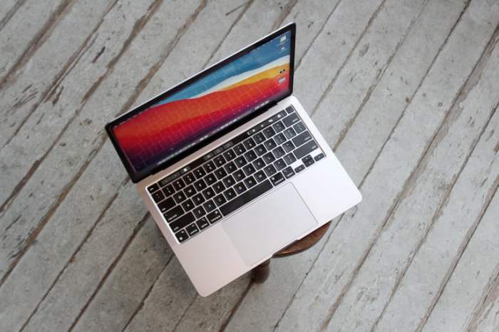 MacBook Pro 13 sobre un banco y al fondo piso de madera, una de las mejores laptops de 13 pulgadas