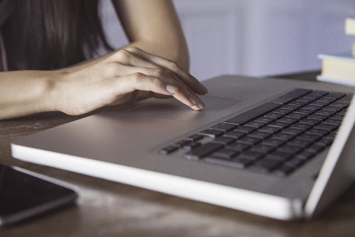 Una persona presiona el panel táctil o touchpad de su computadora.