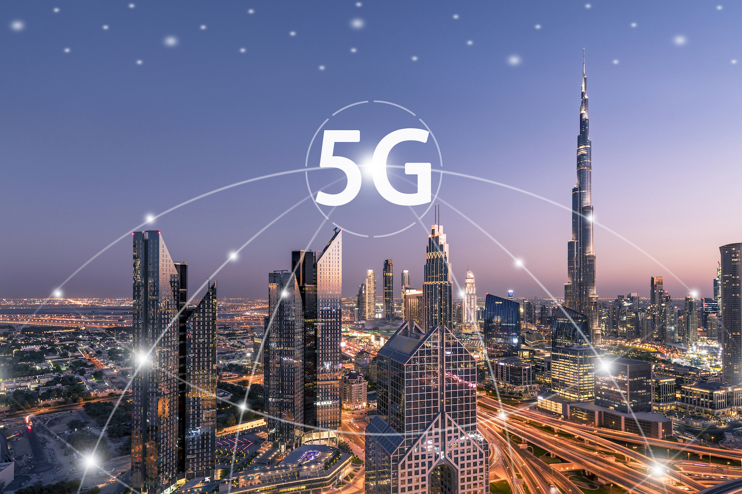 Una ciudad de noche mostrando sus edificios y encima de ellos el logotipo de 5G.
