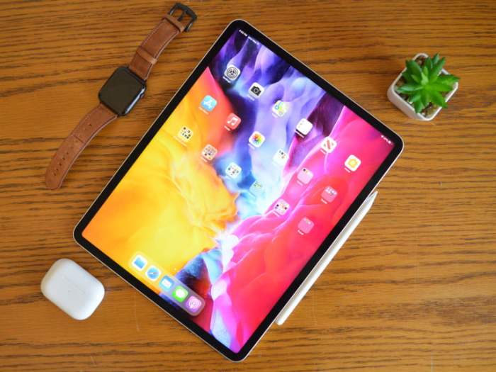 Tableta de Apple sobre un escritorio junto a un reloj y una plantita para comparar iPad Pro (2021) vs. Surface Pro 7