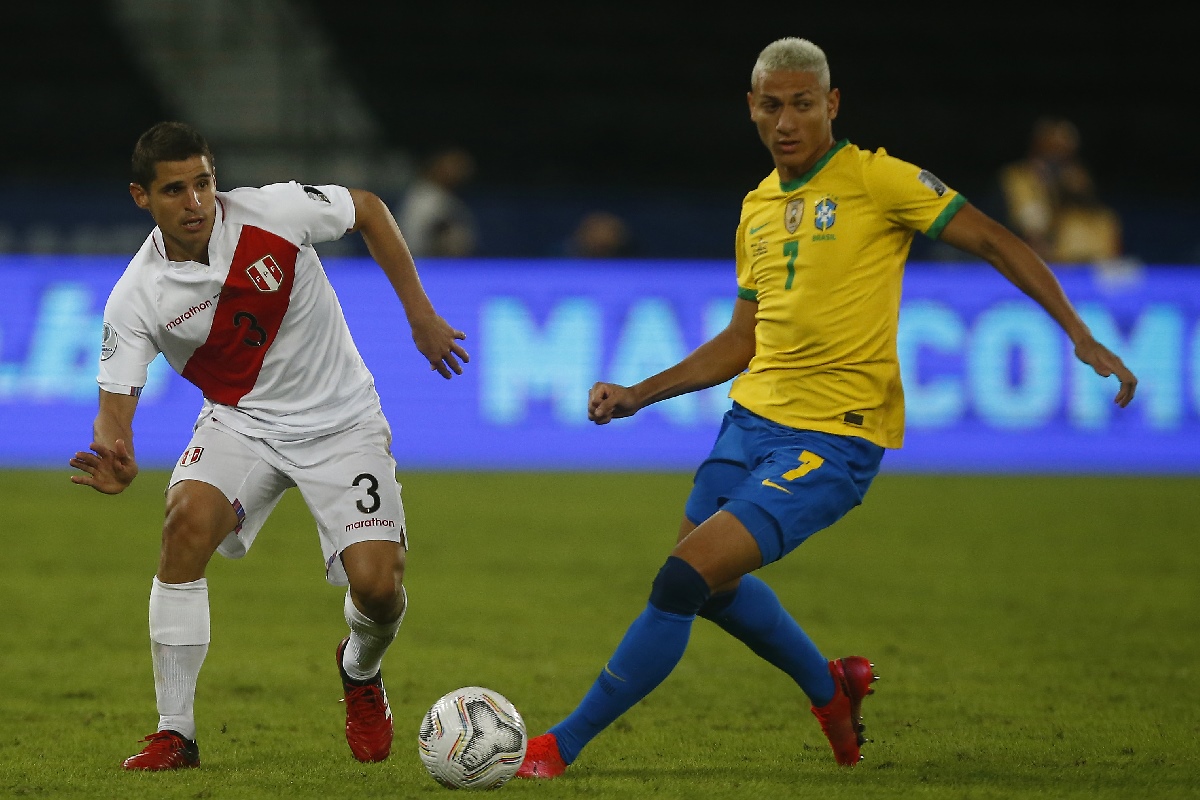 El brasilelño Richarlison enfrenta la marca del peruano Aldo Corzo en un partido por la Copa América 2021.