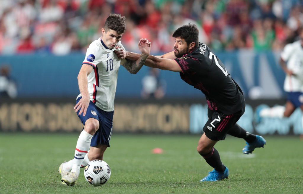 El mexicano Néstor Araujo trata de detener al estadounidense Christian Pulisic durante la final de la Nations League 2021