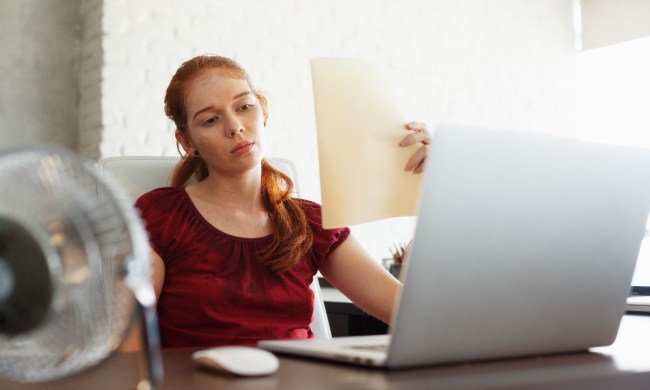 Una mujer transpira con la ola de calor mientras trabaja con su computadora