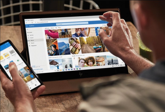 Un hombre usando su celular y su tableta para investigar qué es Microsoft OneDrive