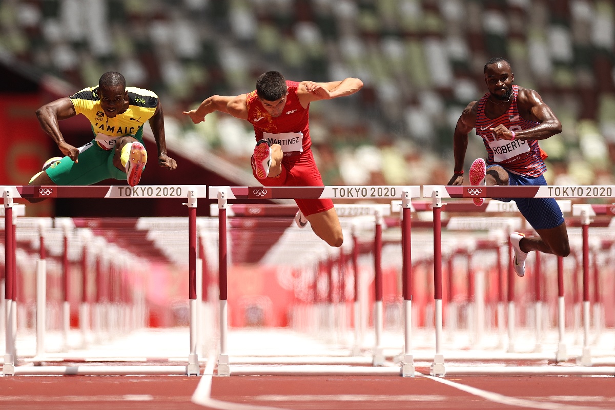 El español Asier Martínez (en el centro) junto al jamaicano Ronald Levy (izquierda) y el estadounidense Daniel Roberts (derecha) en la semifinal de los 100 metros vallas de Tokyo 2020.