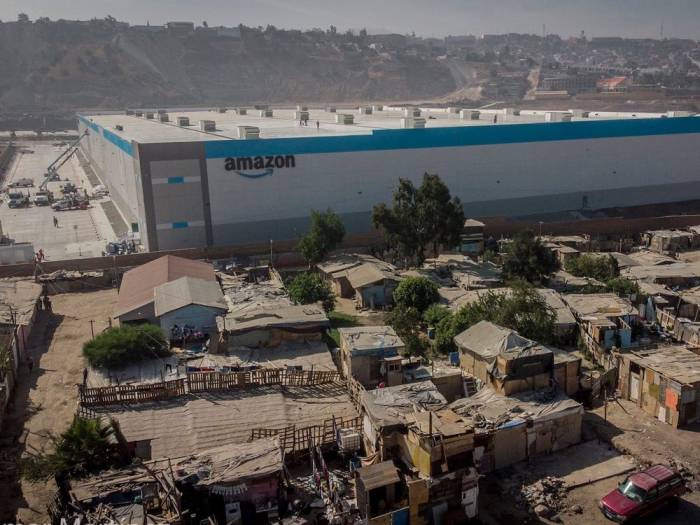 La imagen muestra un nuevo edificio de Amazon en medio de un sector pobre de Tijuana.
