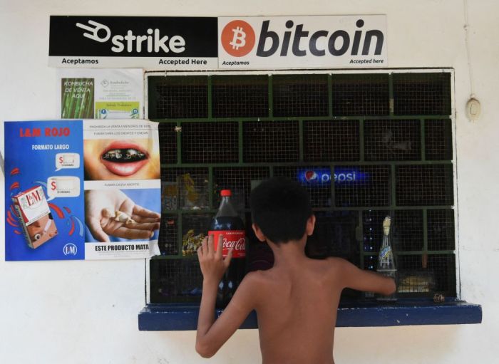 La imagen muestra a un niño comprando en un negocio de El Salvador.