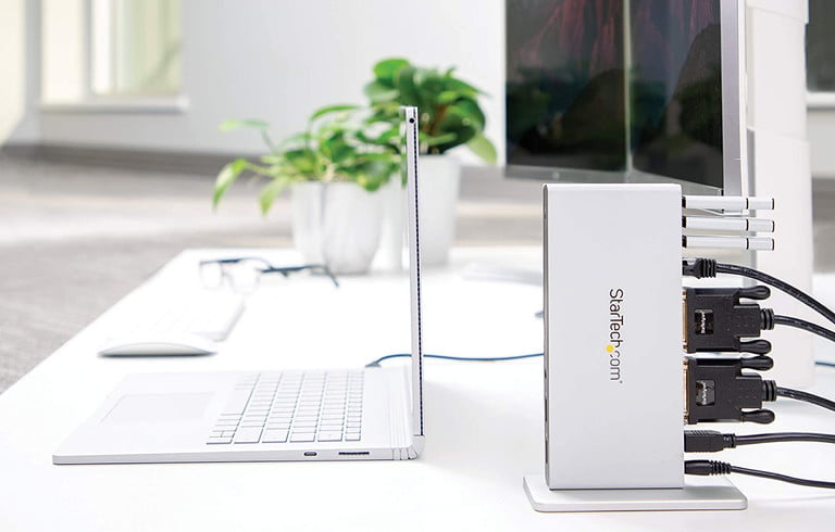 Una de las mejores estaciones de acoplamiento es la de doble monitor StarTech, que se muestra en un escritorio conecta una computadora portátil y dos monitores.