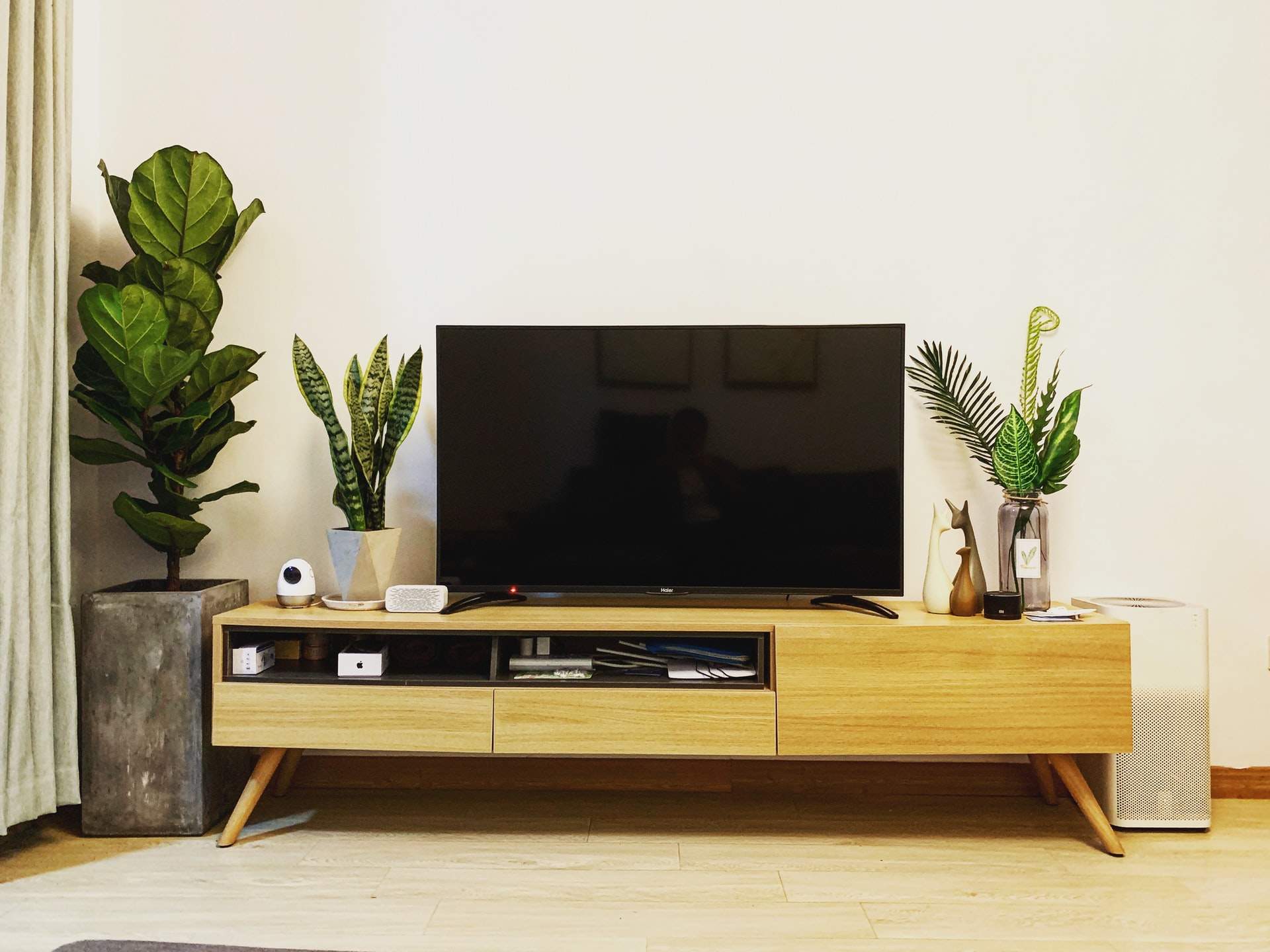 Televisor sobre una consola en la sala de una casa para aprender a cómo conectar Alexa al TV