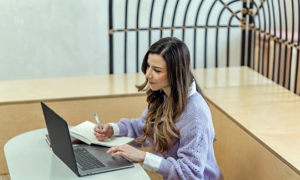 Una mujer con su laptop nueva lista para desinstalar el bloatware.