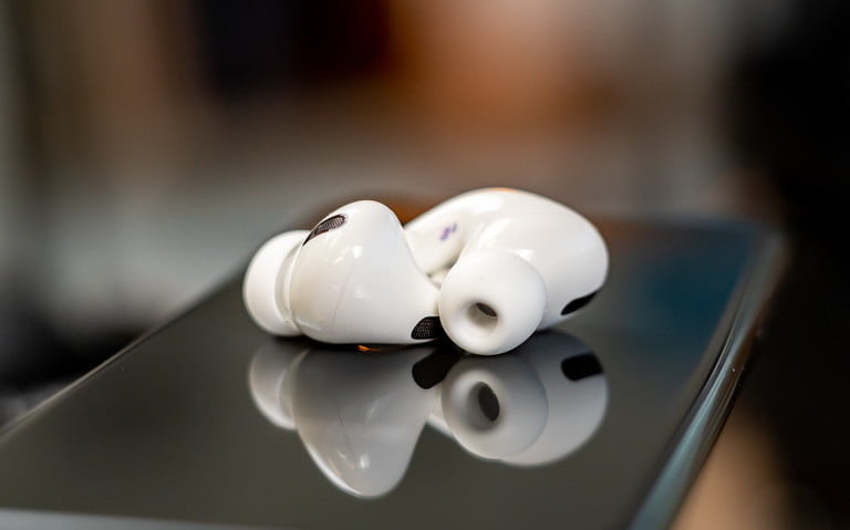 Airpods Pro sobre una superficie brillante para conocer los problemas más comunes de los AirPods