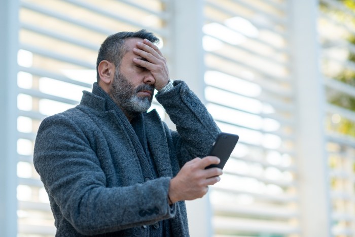 Un hombre molesto por haber perdido su celular, tratando de averiguar cómo localizar un teléfono perdido.