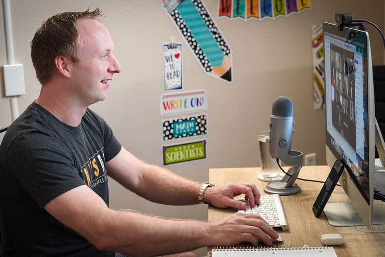 Hombre usando computadora iMac con webcam para aprender cómo grabar un video en Mac