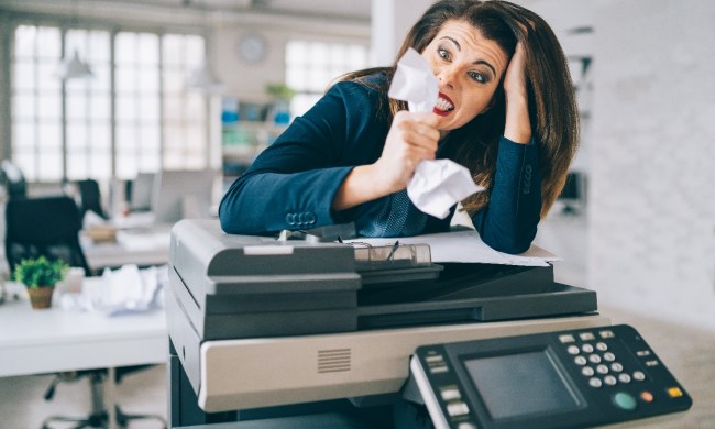 Una mujer enfadada intenta imprimir un documento