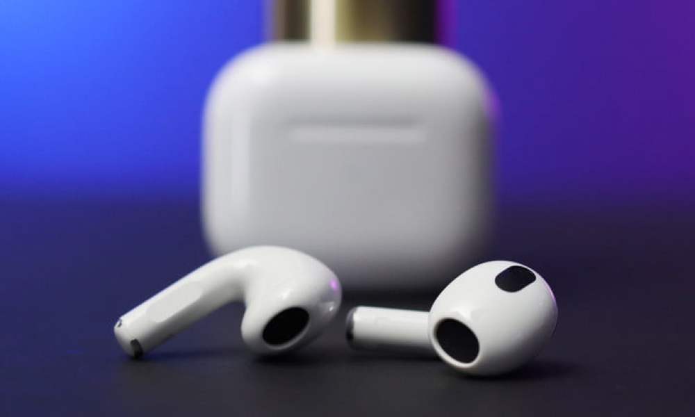 AirPods 3 con estuche de fondo para comparar AirPods vs. AirPods Pro.