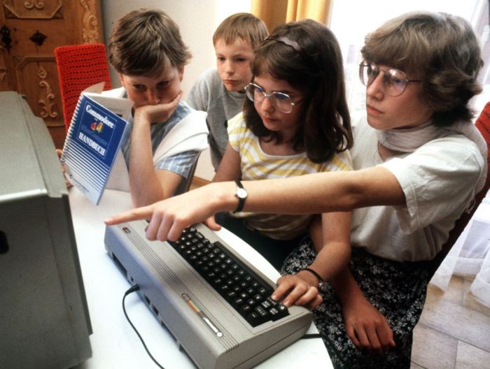 Varios adolescentes juegan con una computadora Commodore 64
