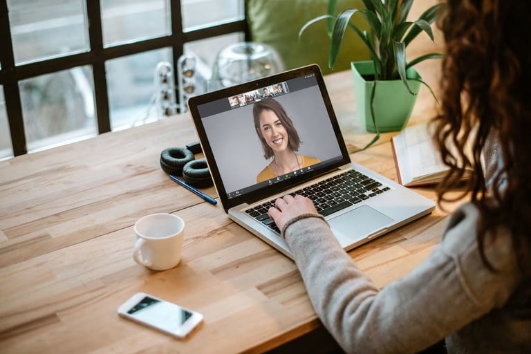 Una mujer en videollamada con otra mujer a través de Zoom, tratando de corregir uno de los problemas más comunes en Zoom