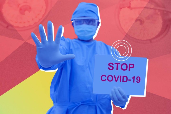 Un médico con un traje de protección con un cartel en la mano que dice: "Detengan al COVID-19".