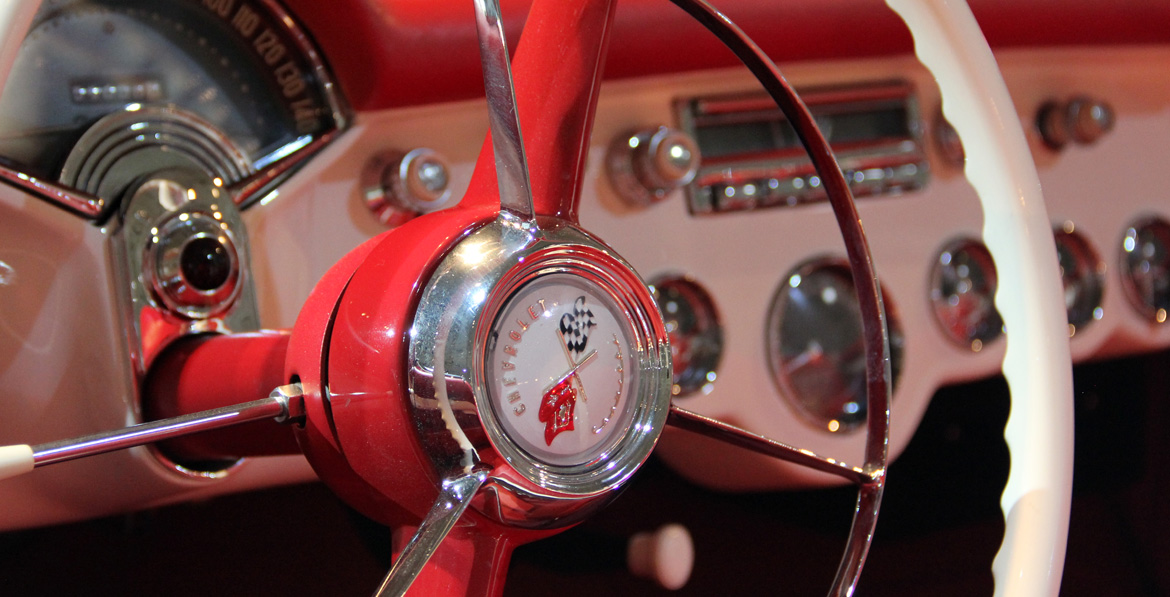 Detalle del tablero de instrumentos y controles del Chevrolet Corvette 1953 con foco en el centro del volante.