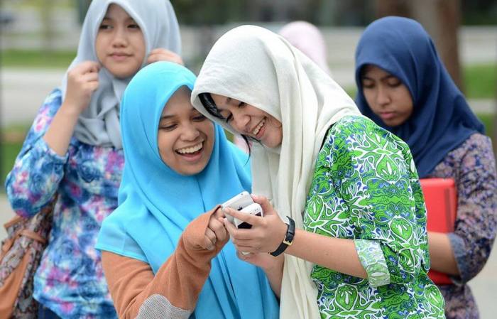 Mujeres utilizando teléfonos móviles en Indonesia.