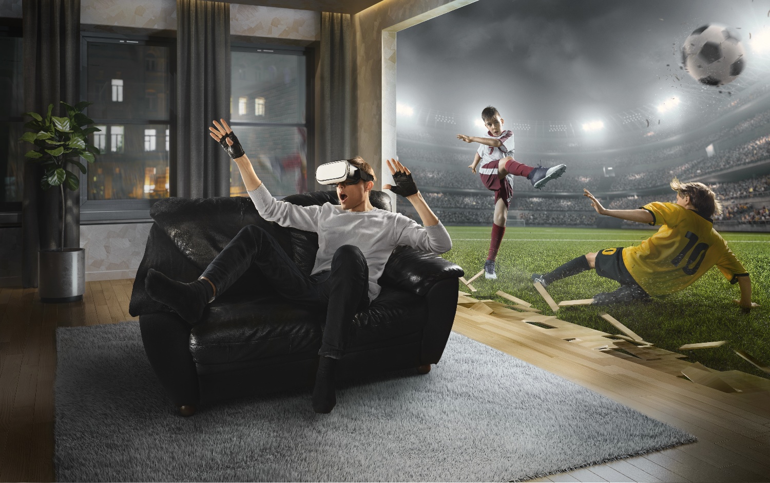 Un hombre sorprendido mientras usa visores de realidad virtual en la sala de estar de su casa, mientras en la pantalla se proyecta un partido de fútbol.
