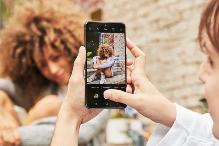 Una mujer tomando una foto a otra mujer con un teléfono, para comparar Samsung Galaxy S21 FE vs. Google Pixel 6.