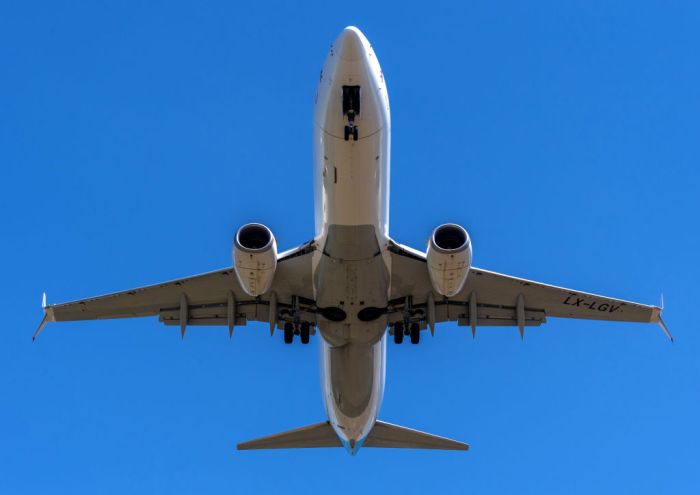 La imagen muestra la parte inferior de un avión mientras despega.